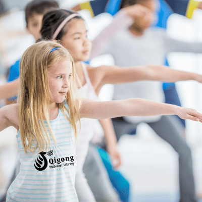 A group of kids doing yoga the front girl has Qigong DeForest Library on her shirt
