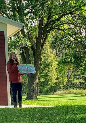 Miss Emily reading a story at a local park